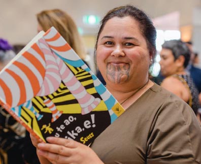 A woman reading Nōu te Ao, e Hika e!